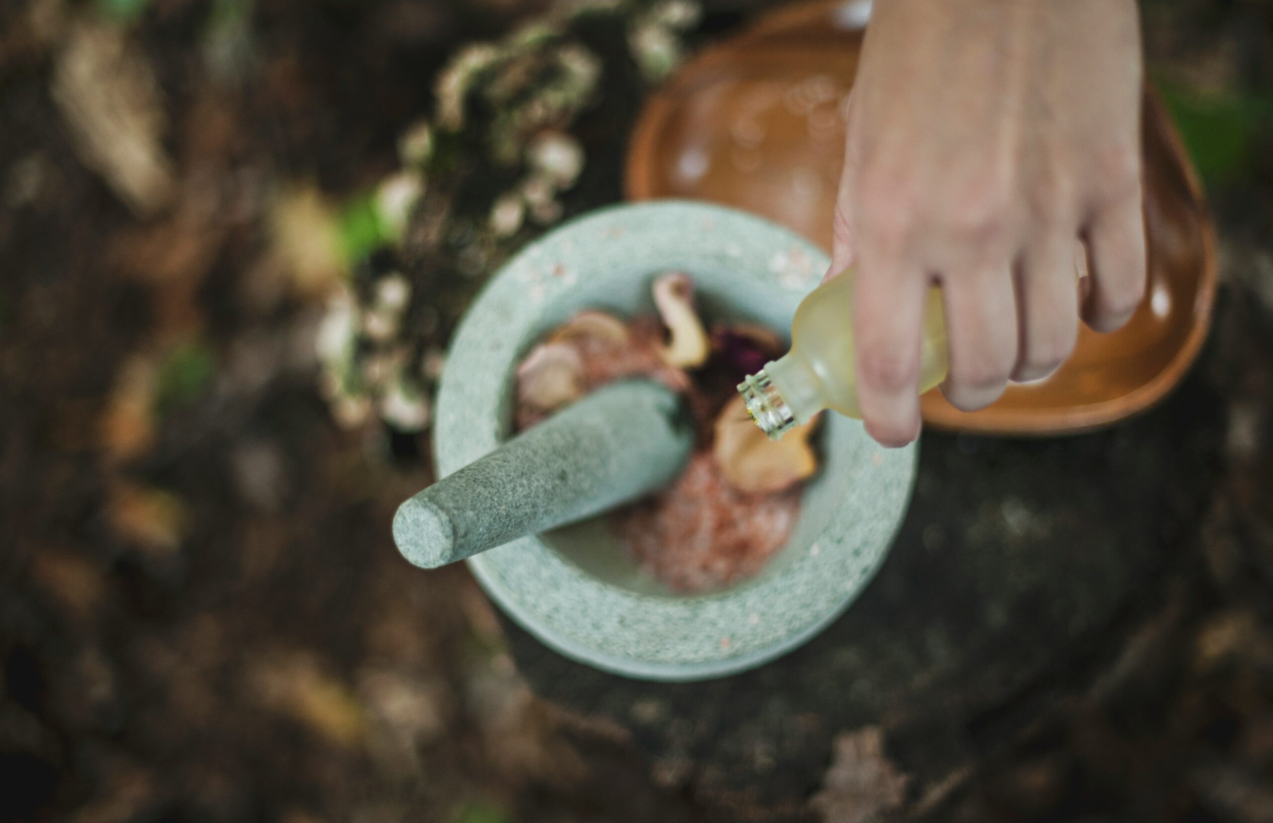 A steaming cup of lemon balm tea surrounded by fresh leaves.